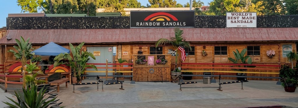 Interior of the Rainbow&reg; Sandals Factory Outlet: sandals and shoes displayed on wooden shelving under warm lighting.